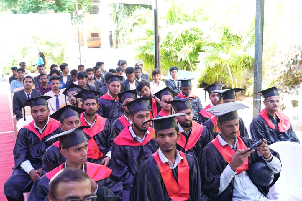 Male graduating students seated in rows wearing graduation gowns and caps.