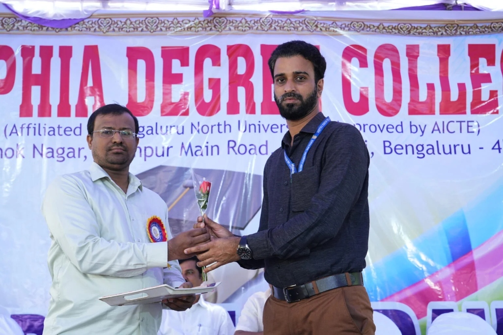 A man receiving a certificate and a rose at the graduation event.