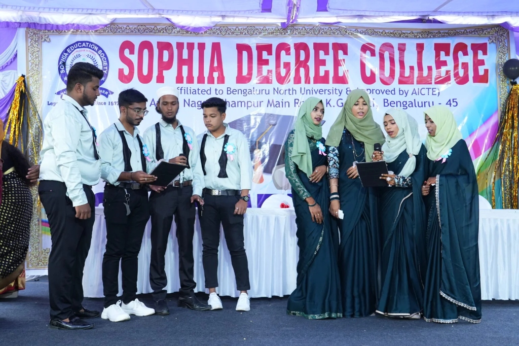 A group of male and female students standing and speaking at the graduation ceremony.