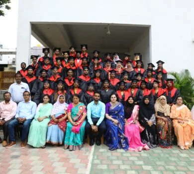 A large group of graduates in full academic regalia posing for a graduation photo.