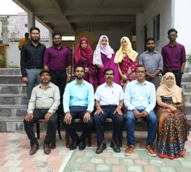 Faculty members and students taking a group photograph on graduation day.