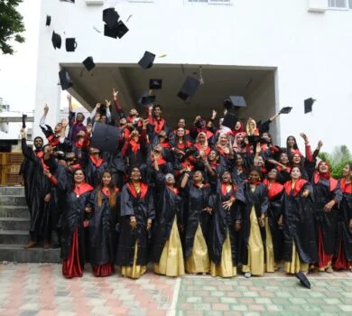 A large group of graduates celebrating by throwing their graduation caps in the air.