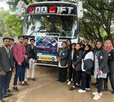 Students and faculty posing for a group photo in front of the tour bus.