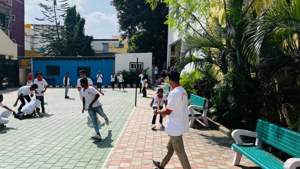 A student throwing the ball over the net during a sports day match.